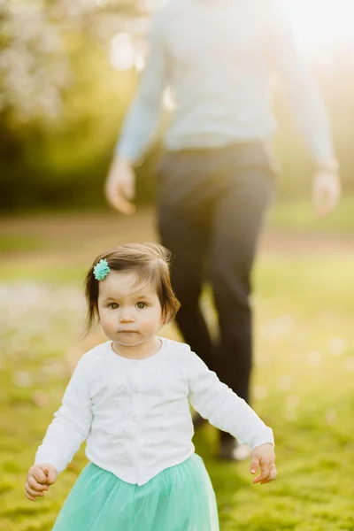 Kleuter meisje wegrennen van de vader op achtergrond in park — Stockfoto