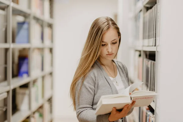 Όμορφη γυναίκα μάθησης των μαθητών σε μια βιβλιοθήκη γυμνασίου — Φωτογραφία Αρχείου