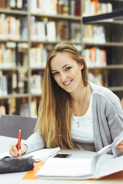 Estudante bonita do sexo feminino com laptop e café aprendizagem em uma biblioteca do ensino médio — Fotografia de Stock