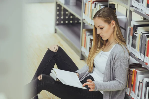 güzel kız öğrenci bir yüksek okul kütüphanesinde öğrenme 