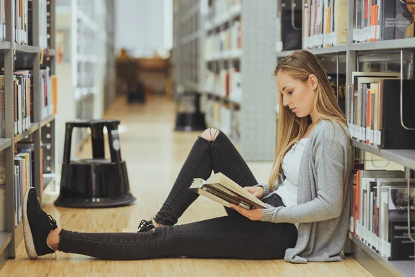 güzel kız öğrenci bir yüksek okul kütüphanesinde öğrenme 