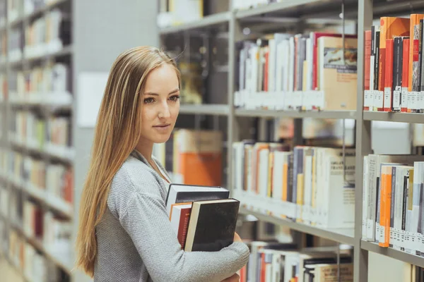 Όμορφη γυναίκα μάθησης των μαθητών σε μια βιβλιοθήκη γυμνασίου — Φωτογραφία Αρχείου