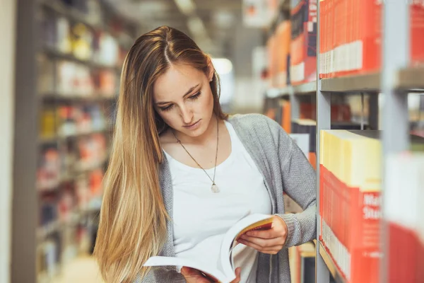 güzel kız öğrenci bir yüksek okul kütüphanesinde öğrenme 