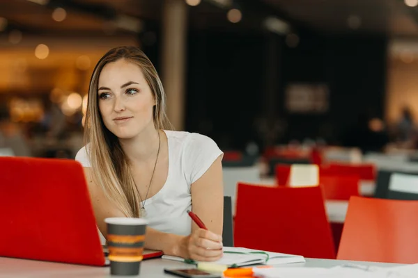 Estudante bonita do sexo feminino com laptop e café aprendizagem em uma biblioteca do ensino médio — Fotografia de Stock