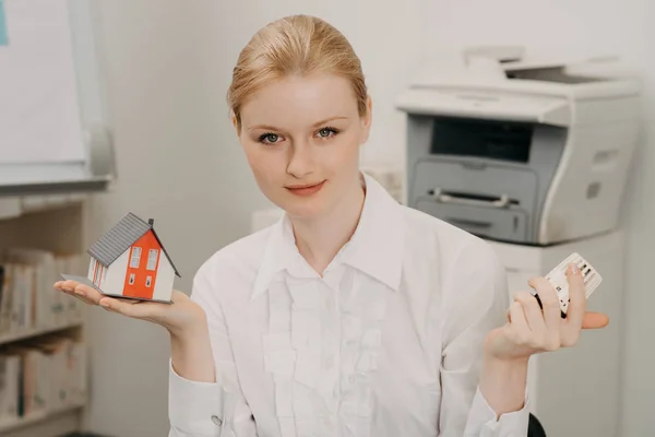 Schöne Frau im Amt mit Modell von Haus und Thermostat. — Stockfoto