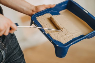 Adam elindeki boya silindiri boya tepsi daldırma yakın çekim