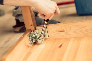 adam ahşap bir masa bacaklarda vidalar