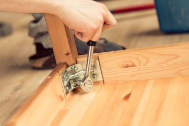 adam ahşap bir masa bacaklarda vidalar