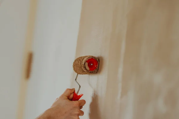 Close-up van de handen van de jonge man schilderen muur met een roller — Stockfoto