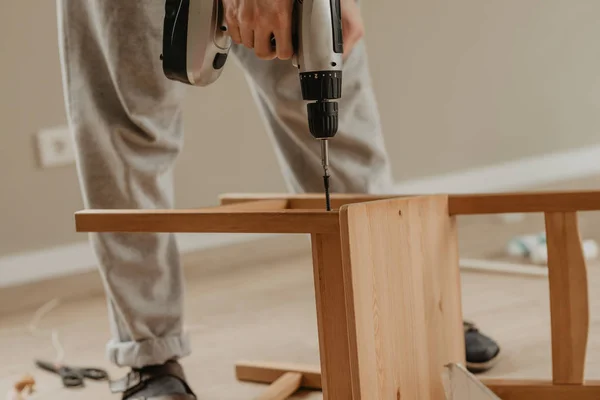 Закрыть руки работника винт стул с электронной отверткой — стоковое фото