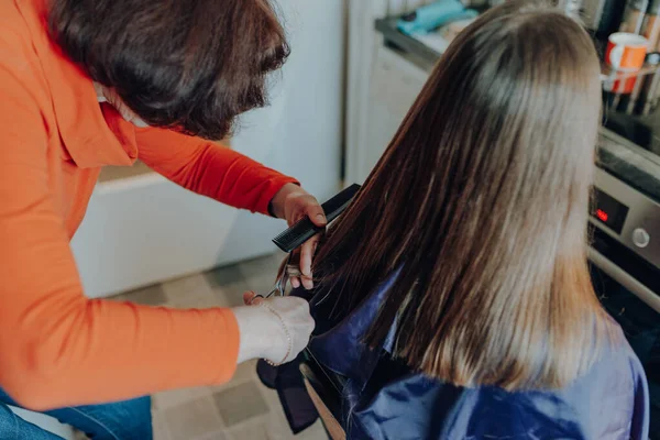 Reife Frau Schneidet Jungen Frau Mit Langen Haaren Hause Haare Stockbild