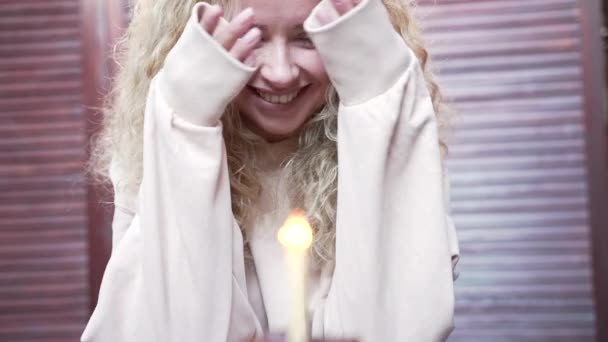 Красивая Кудрявая Блондинка Загадывает Желание Задувает Свечу Свой День Рождения — стоковое видео