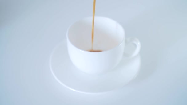gros plan du café versé dans une tasse blanche sur une table blanche 