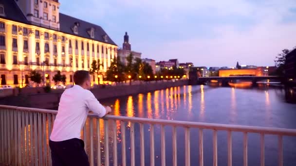 Samiec Turysta Stoi Moście Spoczywając Poręczy Patrząc Rzece Nocy Lub — Wideo stockowe