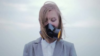 Solunum cihazındaki kız ya da koruyucu maske. Gözünü kapar ve dibe bakar. - Dışarıda. Kötü ekoloji kavramı. Sarışın kız öğrenci salgını virüsü, hava kirliliği veya Dünya 'yı koruma konsepti