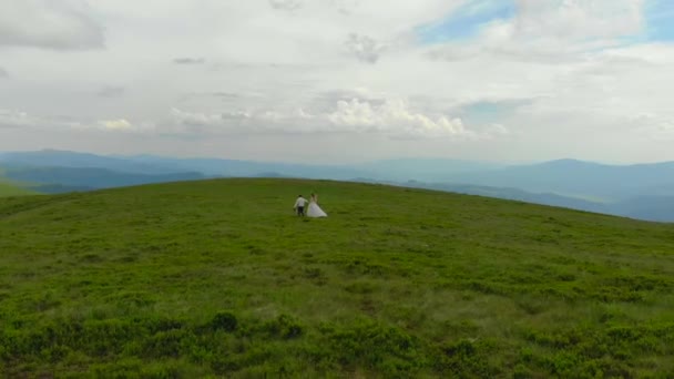 Jovem Casal Casamento Andando Cima Montanhas Verdes Contra Pano Fundo — Vídeo de Stock