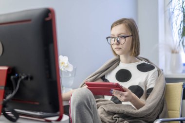 Üniversitede ya da üniversitede uzaktan öğrenim gören bir kız öğrenci. Uzaktan bilim. Evde bir internet sitesi için webinar öğretiyor. Bir özet ya da not defterindeki notlar. Telefon tableti. karantina sırasında