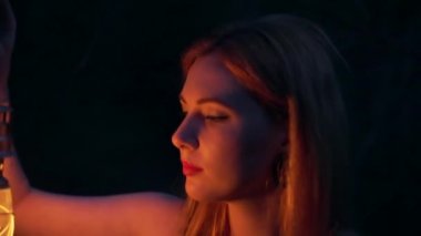 Mistik ormanda gazyağı lambasıyla genç bir kız. Gece vakti elinde fener mumuyla siyah elbiseli bir kadın ya da karanlık ormanda bir ışık. Genç olan ağaçların arasında kayboldu. tehlikeli fantastik ışık