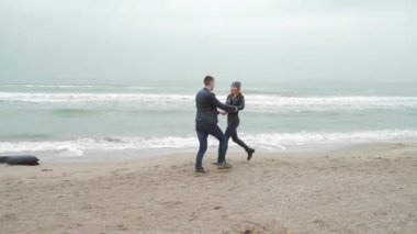 Sevgi dolu bir çift kış plajında birlikte koşuyor. Erkek ve kız kızıl saçlı. Siyah giysiler içinde. Soğuk, yağmur, gülümseyen el ele tutuşmalar, zıplamalar. Deniz kıyısında ya da okyanusta. Dalgalar. Ağır çekim. hikaye