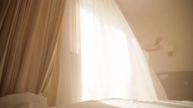 Pastel gölgeler. Güzel kız ya da sarışın kadın iç çamaşırları panoramik pencereye kadar tül ve perdelerle koşar ve sabah uyanır. Arka planda güneş şık iç kısımlarda parlıyor. taze fitness