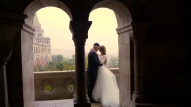 Kendine güvenen damat ilk kez mutlu bir gelinle tanışır, onu gelinlik içinde, pencerenin kenarında bir siluet görür. Evli çift, eski Castle City arka planındaki kemer ve sütunların yanında sarılıp öpüşüyor.