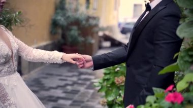 Portre seven genç bir çift, beyaz elbiseli bir gelin, siyah takım elbiseli bir damat. El ele tutuşmak, öpüşmek, eski şehrin dar sokaklarında sarılmak bitkiler, çiçekler, sarı duvarlar arasında.