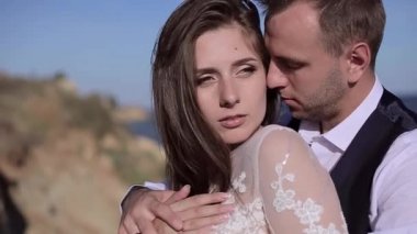 Yakın plan, büyüleyici genç bir çiftin portresi. Gelinlik içinde. Lüks lüks, ciddi gelin ve damat, iki yüzlü. Adam saça dokunuyor. Omzundan öpücükler. Romantik gözler