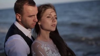 Yakın plan, büyüleyici genç bir çiftin portresi. Gelinlik içinde. Lüks lüks, ciddi gelin ve damat, iki yüzlü. Adam saça dokunuyor. Omzundan öpücükler. Romantik gözler