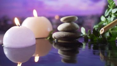 Spa Still Life, Stones masajı ve Su Rahatlaması. Kapatın. Yanan mumların rahatlatıcı görüntüsü. Bulanık arka planda su yansıması. Rahatlama, sakinlik, meditasyon, huzur ve sessizlik.