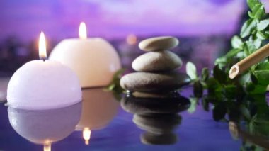 Spa Still Life, Stones masajı ve Su Rahatlaması. Kapatın. Yanan mumların rahatlatıcı görüntüsü. Bulanık arka planda su yansıması. Rahatlama, sakinlik, meditasyon, huzur ve sessizlik.