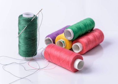 Beyaz arka plan üzerinde renkli bobin iplik