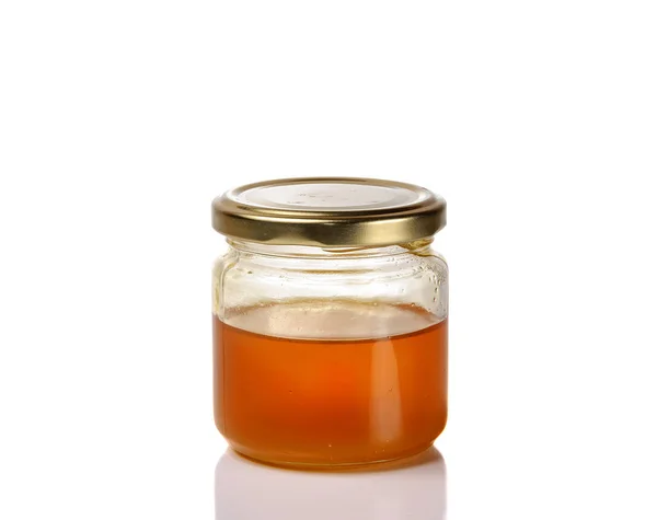 Jar of light golden honey isolated on a white background Stock Image