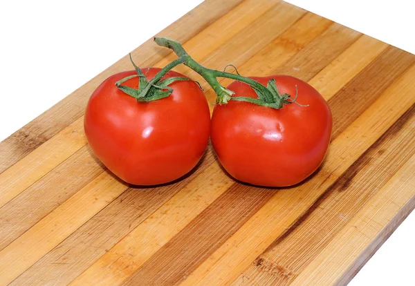 Close up of fresh tomatoes in drops of water on a wooden board — Stock Photo, Image