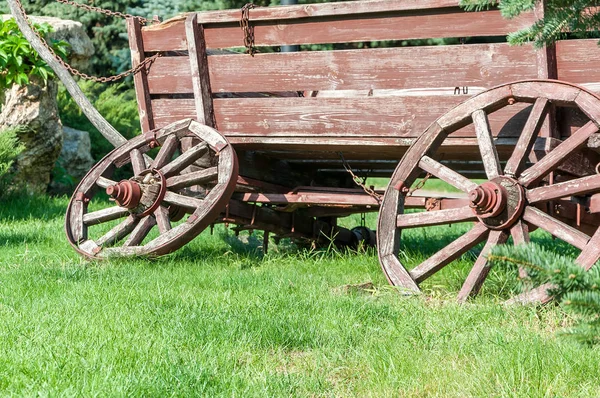Un carro viejo para el transporte en la hierba verde de cerca — Foto de Stock