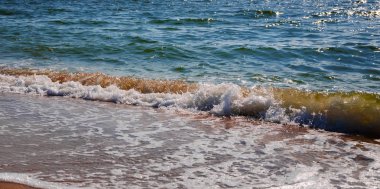 Deniz dalgası güneşli bir öğleden sonra kumlu bir plaj üzerinde. Tropikal kumlu plaj