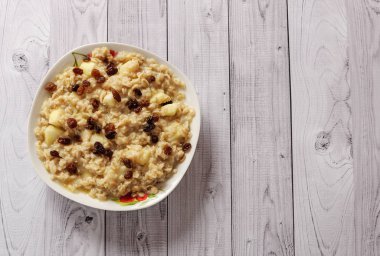 Elma ve üzüm eski ağaç arka planı yulaf ezmesi. Bir elma ve kuru üzüm ile müsli