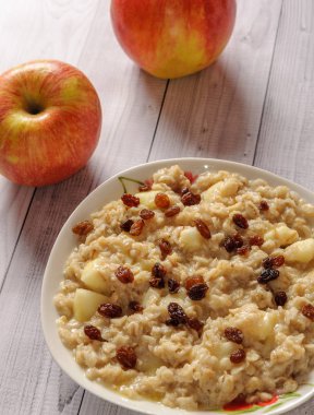 Elma ve üzüm eski ağaç arka planı yulaf ezmesi. Bir elma ve kuru üzüm ile müsli