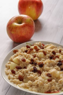 Elma ve üzüm eski ağaç arka planı yulaf ezmesi. Bir elma ve kuru üzüm ile müsli