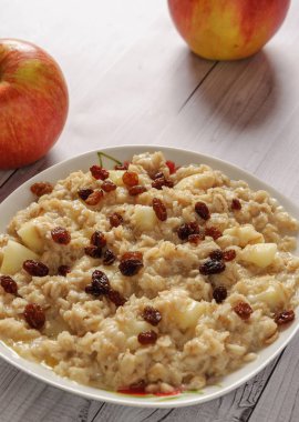 Elma ve üzüm eski ağaç arka planı yulaf ezmesi. Bir elma ve kuru üzüm ile müsli