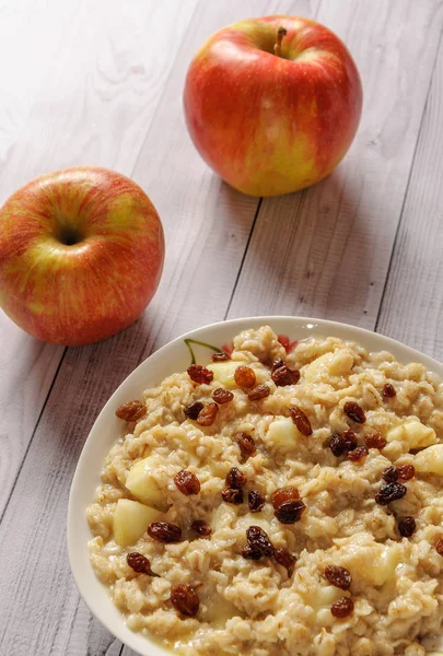Elma ve üzüm eski ağaç arka planı yulaf ezmesi. Bir elma ve kuru üzüm ile müsli