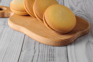 Muz üzerinde eski bir ahşap masa doldurma ile lezzetli bisküviler. Şekerli tatlı