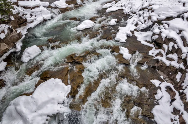 Зимний пейзаж. Горная река течет из скал. Снег и гора — стоковое фото