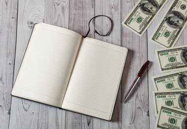 Not Defteri, kalem ve hafif ahşap arka plan üzerinde para