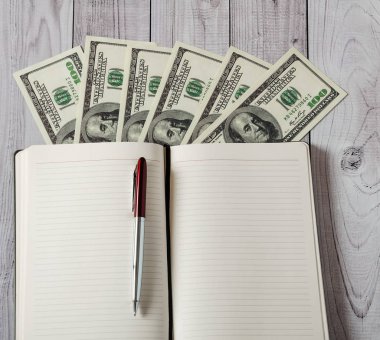 Not Defteri, kalem ve hafif ahşap arka plan üzerinde para