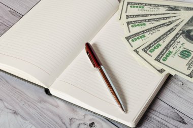 Not Defteri, kalem ve hafif ahşap arka plan üzerinde para