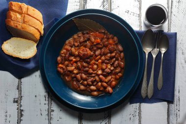 Kırmızı şarap ve baklagiller, sebzeler ve sosislerden oluşan Akdeniz diyetinin ekmekleri ile birlikte fasulye güveci. Geleneksel kaşık mutfağı, soğuk aylar için..