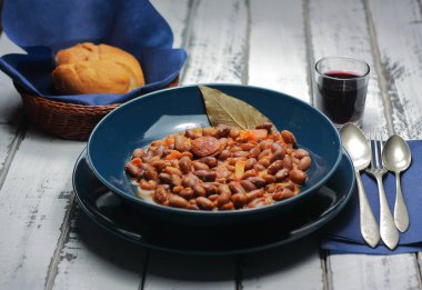 Kırmızı şarap ve baklagiller, sebzeler ve sosislerden oluşan Akdeniz diyetinin ekmekleri ile birlikte fasulye güveci. Geleneksel kaşık mutfağı, soğuk aylar için..