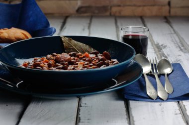 Kırmızı şarap ve baklagiller, sebzeler ve sosislerden oluşan Akdeniz diyetinin ekmekleri ile birlikte fasulye güveci. Geleneksel kaşık mutfağı, soğuk aylar için..