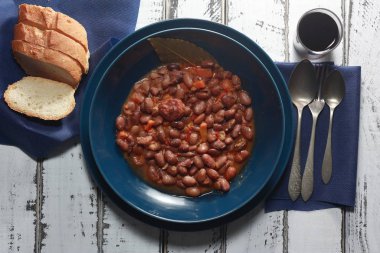 Kırmızı şarap ve baklagiller, sebzeler ve sosislerden oluşan Akdeniz diyetinin ekmekleri ile birlikte fasulye güveci. Geleneksel kaşık mutfağı, soğuk aylar için..