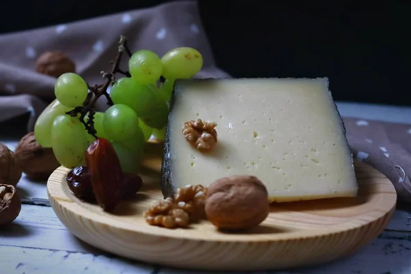 Halbgetrockneter Ziegenkäse Begleitet Von Weißen Trauben Nüssen Und Datteln — Stockfoto